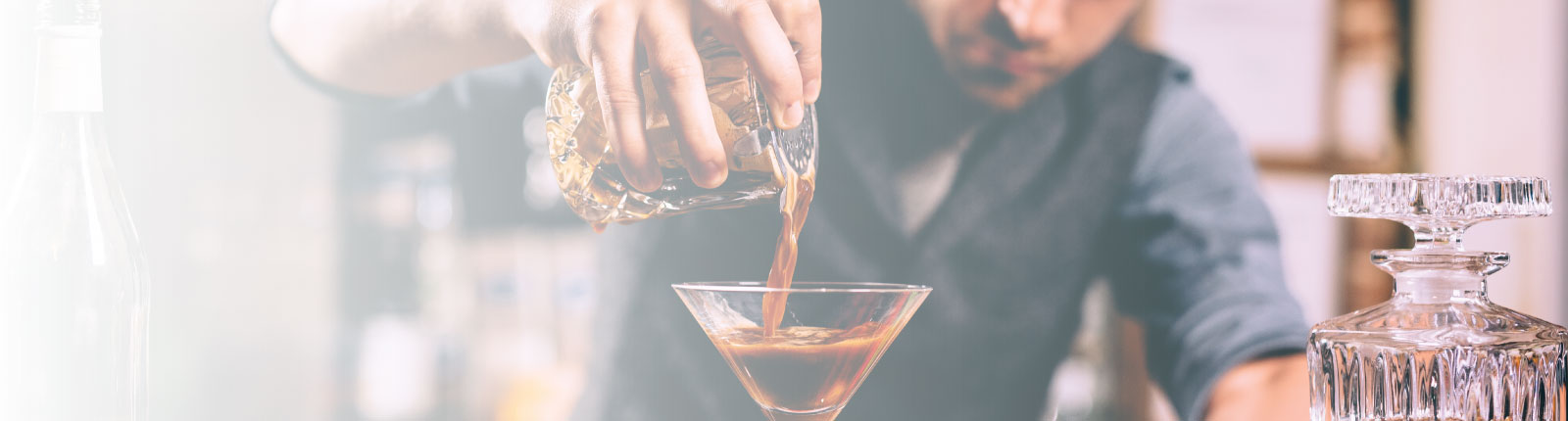 bartender pouring cocktail at bar
